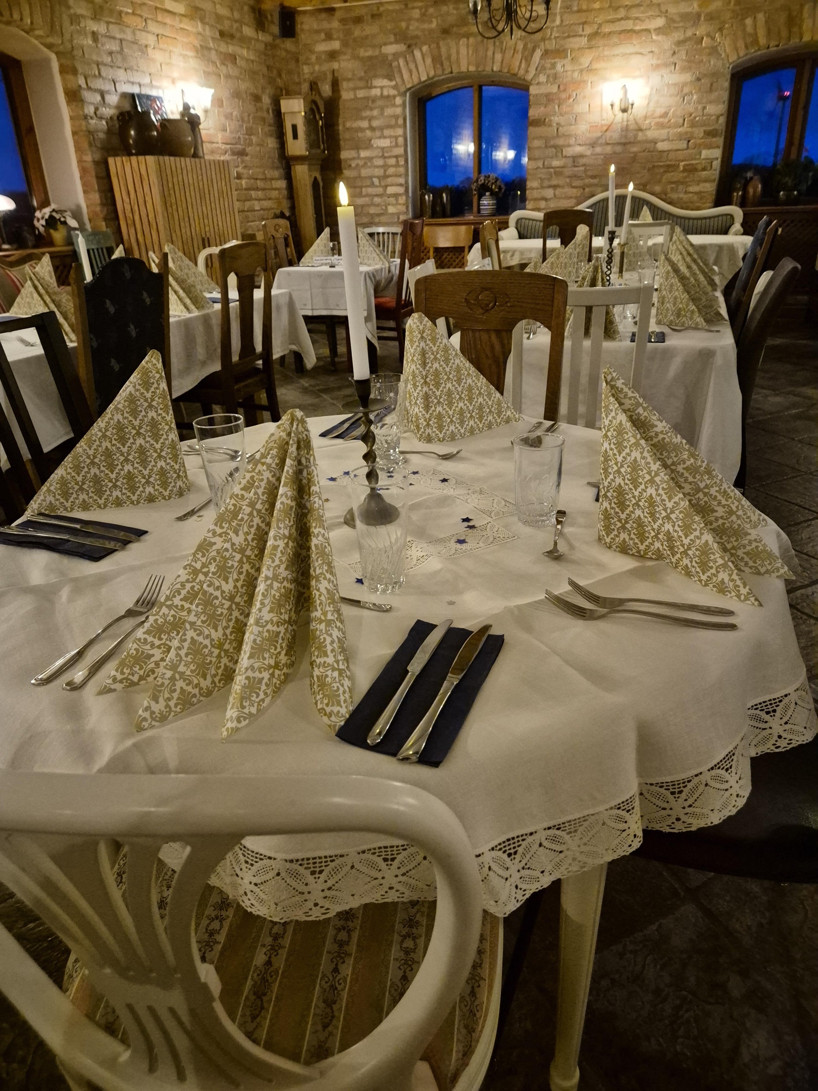Decorated interior for festive event. Fancy table set for dinner with white flower composition in restaurant, luxury interior background. Wedding elegant banquet decoration arranged by catering service